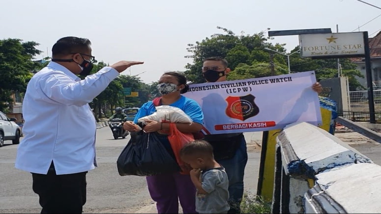 Ketua Presidium ICPW Bambang Suranto saat menyerahkan paket sembako di jalanan.