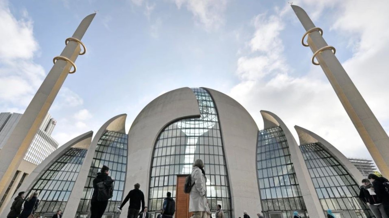 Orang-orang berdiri di luar masjid pusat DITIB pada 'Hari Pembukaan Masjid' di Cologne, Jerman. (Associated Press)