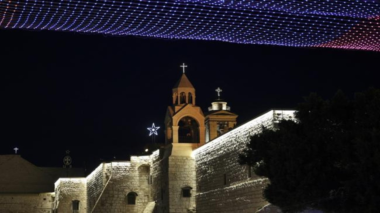 Lampu menghiasi Gereja kelahiran Yesus di Betlehem pada malam Natal 2021, tahun kedua di bawah bayang-bayang pandemi Covid-19. (AFP)
