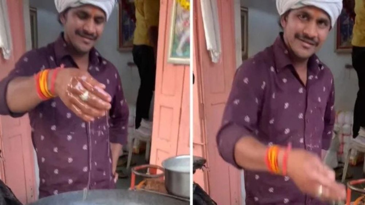 Pedagang gorengan ini mencelupkan tangannya ke dalam minyak panas mendidih sambil senyum. (India Times)