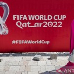 Arsip foto - Seorang wanita berjalan di depan baliho besar logo Piala Dunia FIFA 2022 di West-1668920778