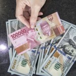 Ilustrasi: Petugas menghitung uang dolar AS dan uang rupiah di salah satu kantor cabang sebuah bank di Jakarta. (ANTARA FOTO/Reno Esnir/foc.)-1669788976