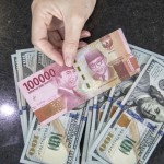 Ilustrasi: Petugas menghitung uang dolar AS dan uang rupiah di salah satu kantor cabang sebuah bank di Jakarta. (ANTARA FOTO/Reno Esnir/foc.)-1669789474