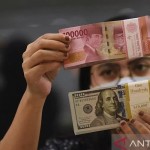 Pegawai menunjukkan mata uang rupiah dan dolar AS di salah satu gerai penukaran mata uang di Jakarta. (ANTARA FOTO/Indrianto Eko Suwarso/YU/aa.)-1668741512