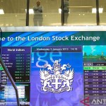 Pekerja terlihat berbincang di atas papan elektronik pergerakan saham di London Stock Exchange, Inggris. REUTERS/Paul Hackett/aa. (REUTERS/Paul Hackett)-1668739745