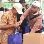 Petugas memberikan paket bahan pokok penting kepada salah satu warga Kelurahan-1668501479