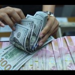 Ilustrasi: Pekerja menghitung uang dolar Amerika Serikat dan rupiah di sebuah tempat penukaran uang di Jakarta. (ANTARA FOTO/Akbar Nugroho Gumay/wsj/pri.)-1671077984