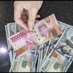 Ilustrasi: Petugas menghitung uang dolar AS dan uang rupiah di salah satu kantor cabang sebuah bank di Jakarta. (ANTARA FOTO/Reno Esnir/foc.)-1671442033