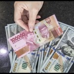 Ilustrasi: Petugas menghitung uang dolar AS dan uang rupiah di salah satu kantor cabang sebuah bank di Jakarta. (ANTARA FOTO/Reno Esnir/foc.)-1671504690