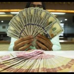 Ilustrasi teller memegang mata uang dolar AS dan rupiah di sebuah tempat penukaran uang, Jakarta, Rabu (6-7-2022). ANTARA FOTO/Subur Atmamihardja/wsj/foc.-1671073715