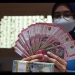 Ilustrasi - Petugas perbankan menunjukkan uang dolar AS dan uang rupiah. (ANTARA FOTO/Reno Esnir/tom/aa)-1687932511