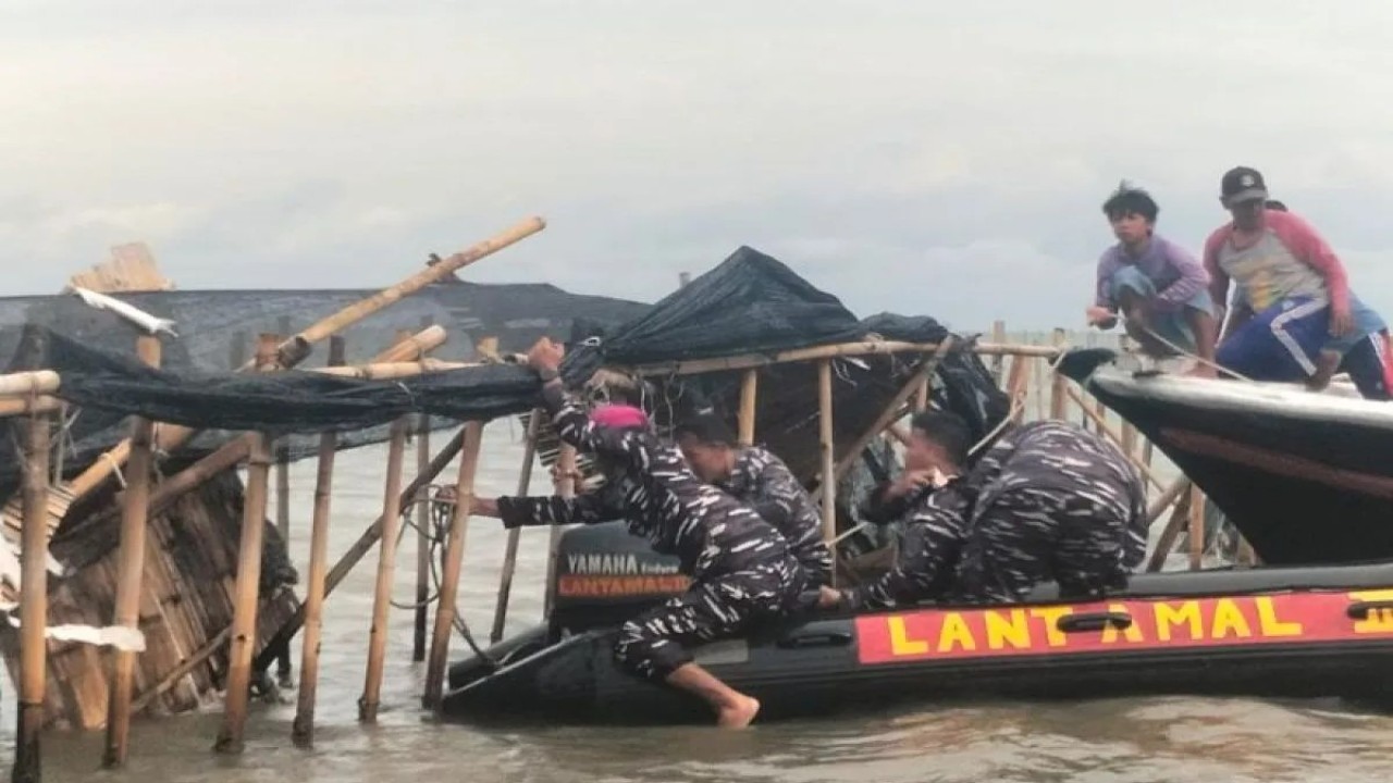 TNI AL bersama dengan masyarakat sekitar  membongkar pagar laut di kawasan Tanjung Pasir, Kabupaten Tangerang, Banten, Sabtu (18/1/2025). (ANTARA/Walda Marison)