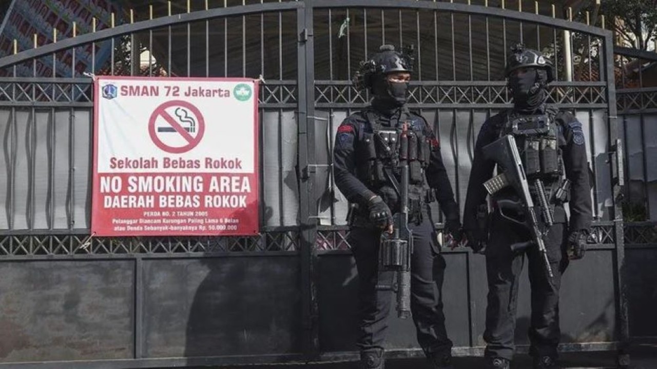 Dua personel Gegana Brimob Polda Metro Jaya berjaga di tempat terjadinya ledakan di SMAN 72 Jakarta, Jakarta, Jumat (7/11/2025). Polda Metro Jaya menyebutkan sebanyak 55 orang mengalami luka-luka dalam ledakan yang terjadi di SMA Negeri 72 Jakarta, K (Antara)